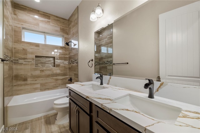 full bathroom featuring toilet, vanity, and tiled shower / bath combo