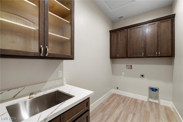 washroom featuring cabinets, sink, washer hookup, hookup for an electric dryer, and light hardwood / wood-style floors