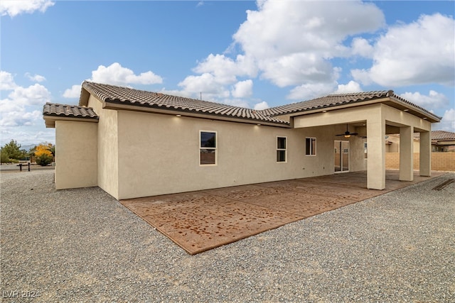 rear view of property with ceiling fan and a patio