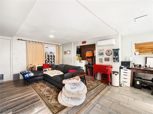 living room with a wall mounted AC, a textured ceiling, and hardwood / wood-style flooring