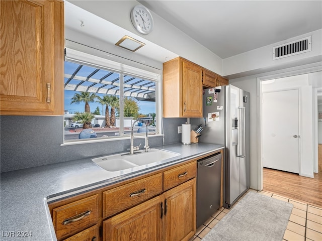 kitchen featuring decorative backsplash, sink, light tile patterned flooring, and stainless steel appliances