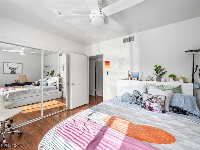 bedroom with ceiling fan, dark hardwood / wood-style floors, and a closet