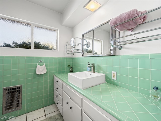 bathroom featuring tile patterned flooring, vanity, heating unit, and tile walls