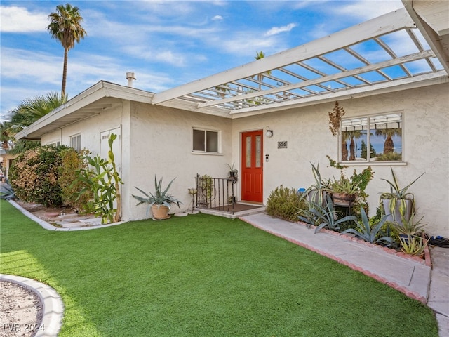 property entrance featuring a lawn