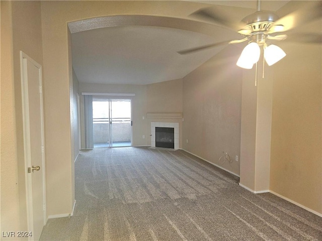 unfurnished living room with ceiling fan, a fireplace, and carpet floors