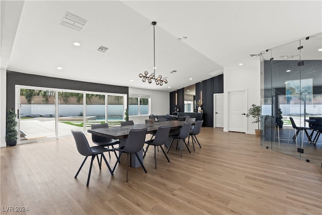 dining area with a chandelier, a wealth of natural light, and light hardwood / wood-style flooring