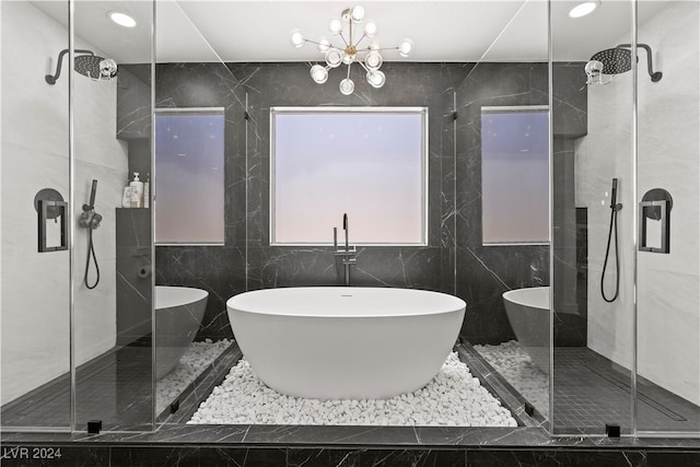 bathroom featuring shower with separate bathtub, tile walls, and an inviting chandelier