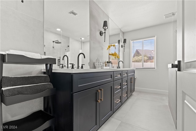 bathroom featuring a textured ceiling, vanity, and a shower with shower door