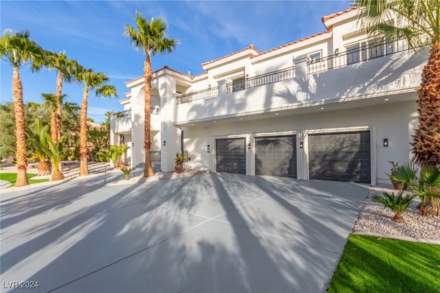 mediterranean / spanish-style home featuring a balcony and a garage