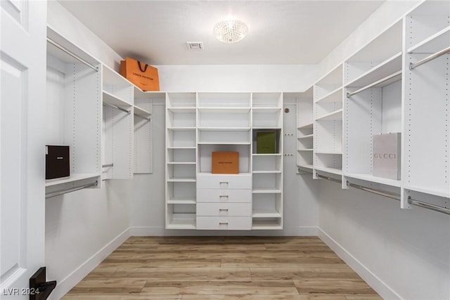 walk in closet with hardwood / wood-style flooring