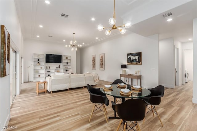 dining area with ornamental molding, a notable chandelier, and light hardwood / wood-style flooring