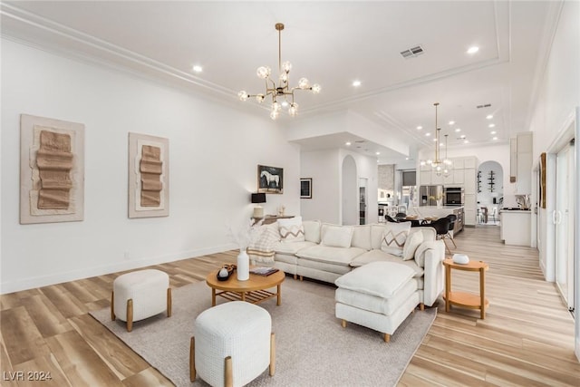 living room with a chandelier, crown molding, and light hardwood / wood-style flooring