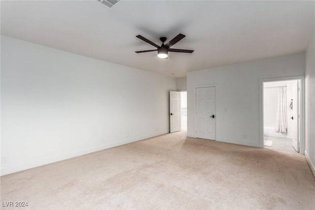 spare room with ceiling fan and light carpet