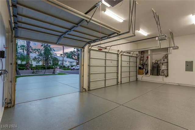 garage at dusk with electric panel and a garage door opener