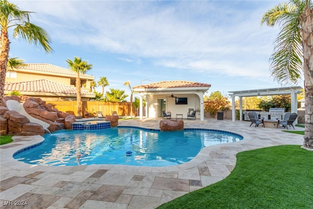 view of pool featuring pool water feature, an outdoor kitchen, an in ground hot tub, ceiling fan, and a patio area