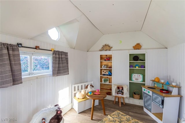 game room with wood-type flooring and vaulted ceiling