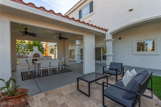 view of patio with ceiling fan and an outdoor living space with a fireplace