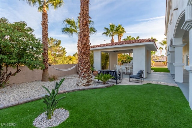 view of yard featuring ceiling fan and a patio