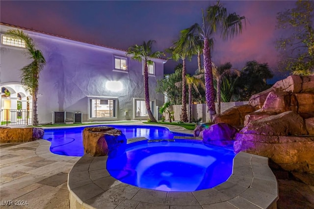 view of swimming pool with a patio area, cooling unit, and an in ground hot tub