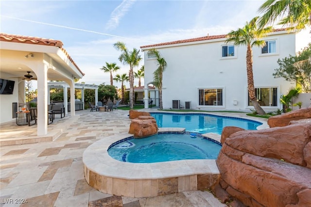 view of swimming pool with a patio area, ceiling fan, and an in ground hot tub