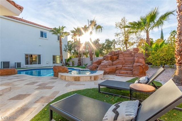 view of pool with central AC unit, an in ground hot tub, and a patio area