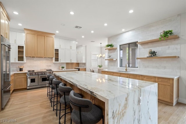 kitchen with a center island, light hardwood / wood-style floors, sink, and appliances with stainless steel finishes