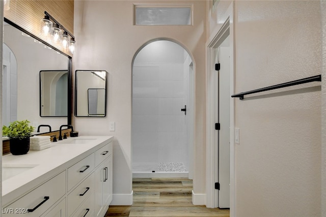 bathroom featuring hardwood / wood-style flooring, vanity, and a shower