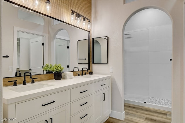 bathroom with wood-type flooring, vanity, and walk in shower