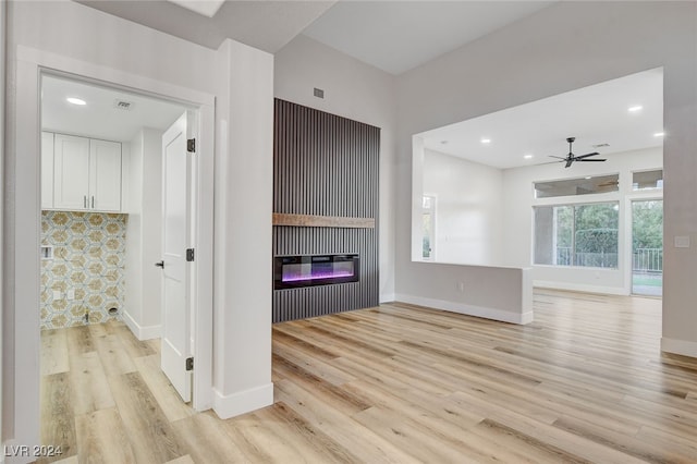 unfurnished living room featuring ceiling fan and light wood-type flooring