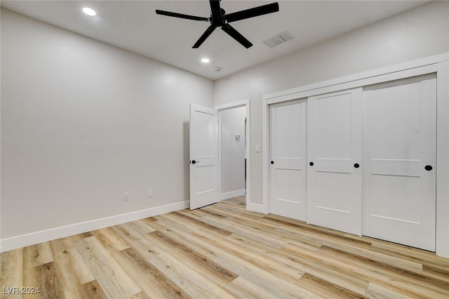 unfurnished bedroom featuring ceiling fan, light hardwood / wood-style floors, and a closet