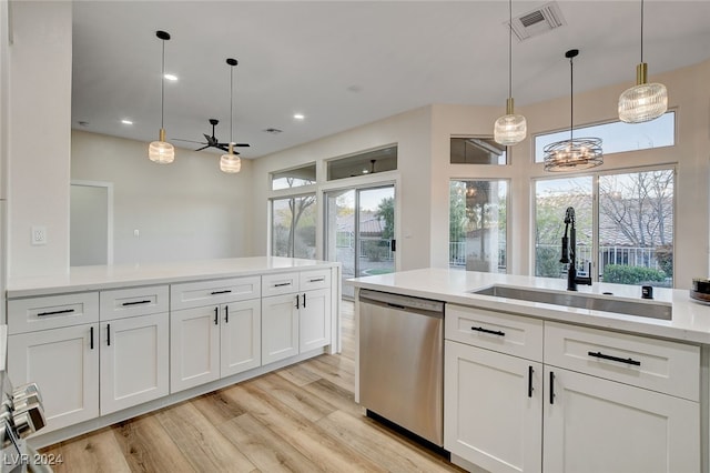 kitchen featuring a wealth of natural light, dishwasher, white cabinets, and sink