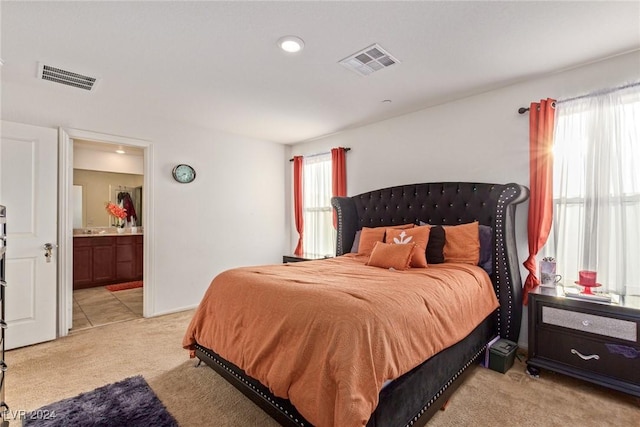 bedroom featuring connected bathroom, light carpet, visible vents, and recessed lighting