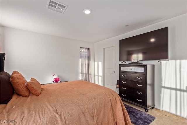 bedroom with visible vents and light carpet