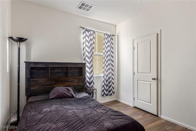 bedroom featuring visible vents, wood finished floors, and baseboards