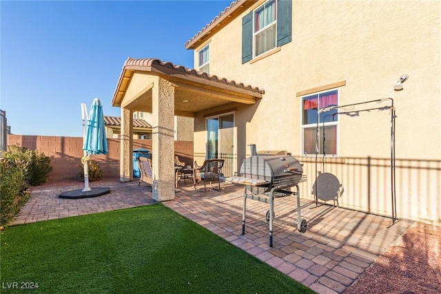 back of house featuring a patio area and a lawn