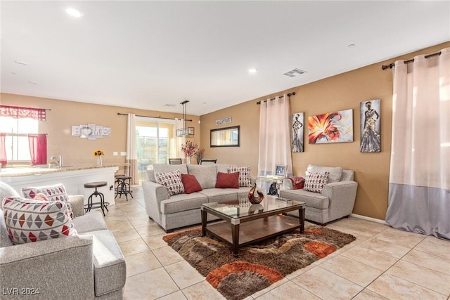 living room featuring sink and light tile patterned floors