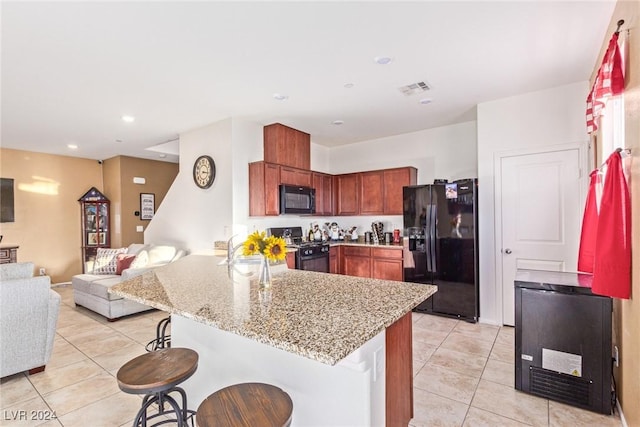 kitchen featuring a kitchen bar, kitchen peninsula, sink, black appliances, and light tile patterned flooring