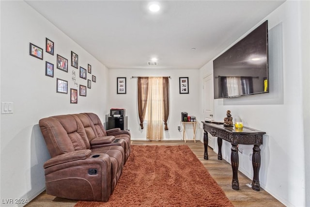 living room featuring visible vents, light wood-type flooring, and baseboards