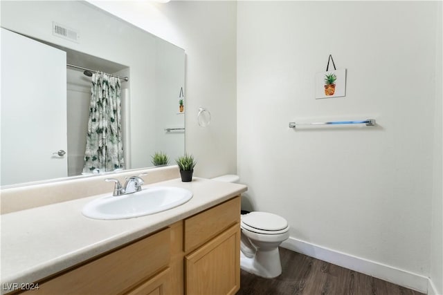 bathroom with vanity, hardwood / wood-style flooring, toilet, and walk in shower