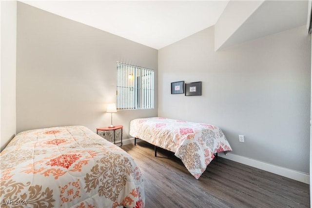 bedroom with vaulted ceiling and dark hardwood / wood-style floors