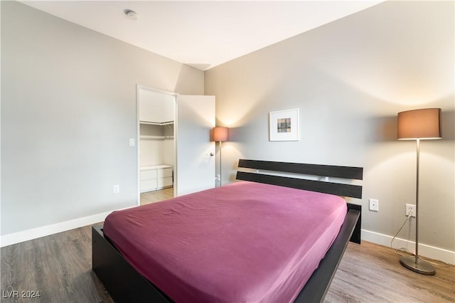 bedroom with wood-type flooring, a spacious closet, billiards, and a closet