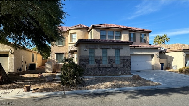 mediterranean / spanish house with cooling unit and a garage