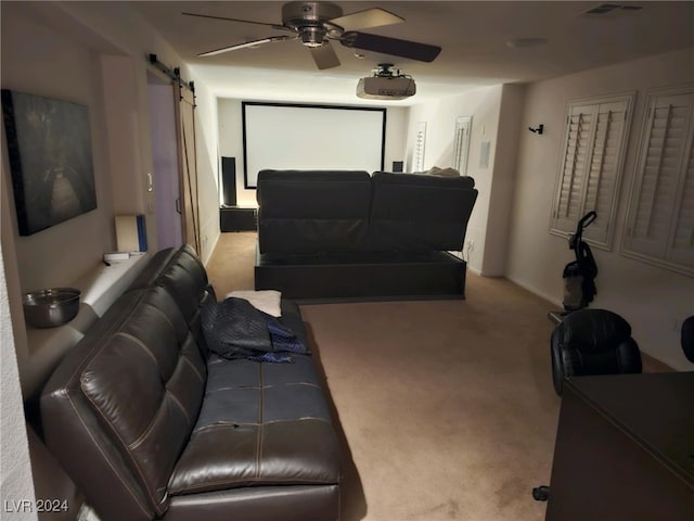 living room featuring a barn door, ceiling fan, and light colored carpet