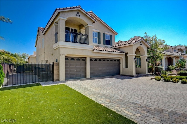 mediterranean / spanish-style house with a garage, a balcony, and a front yard