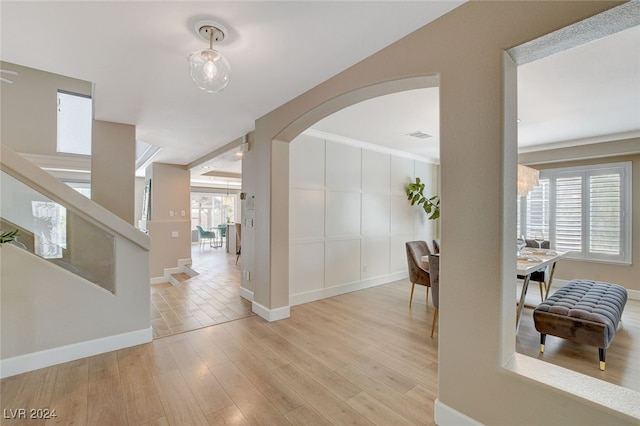 hall with light wood-type flooring and a wealth of natural light