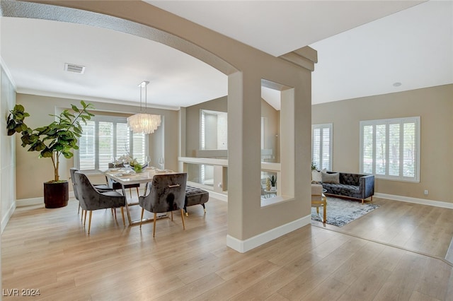 dining room featuring light wood-type flooring and an inviting chandelier