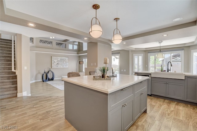 kitchen with light wood-type flooring, a center island, and decorative light fixtures