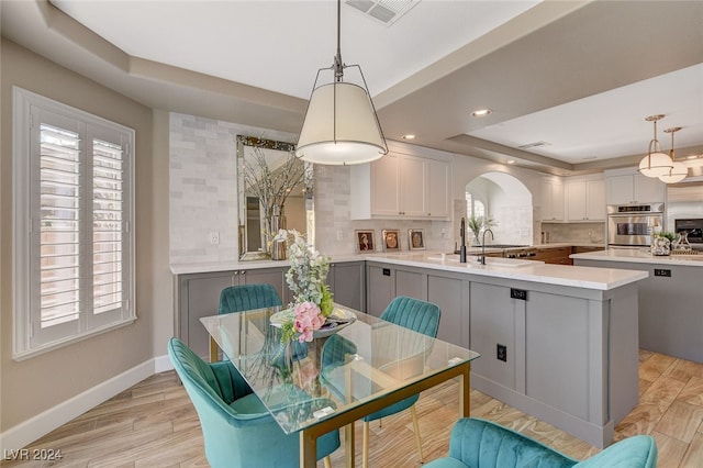 dining space featuring light hardwood / wood-style floors and a raised ceiling