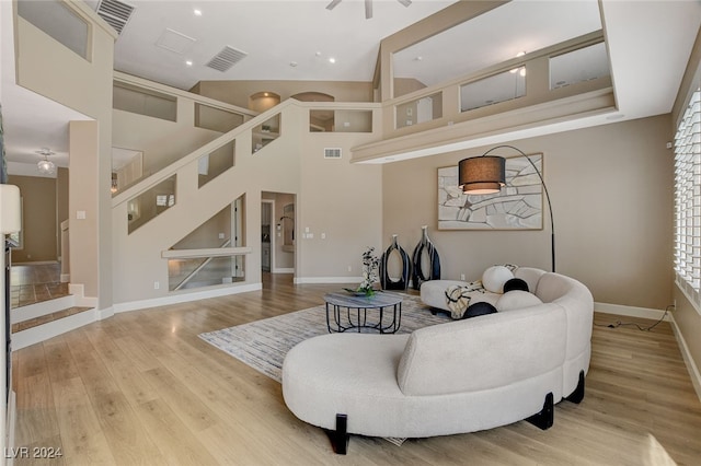 living room with high vaulted ceiling and light hardwood / wood-style flooring