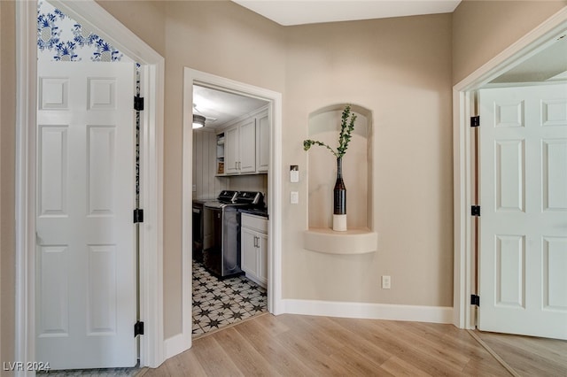 hallway with washer and dryer and light hardwood / wood-style floors